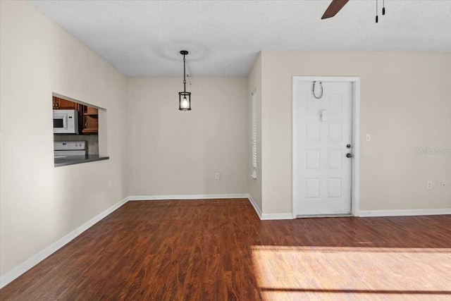 interior space with dark hardwood / wood-style floors, ceiling fan, and a textured ceiling