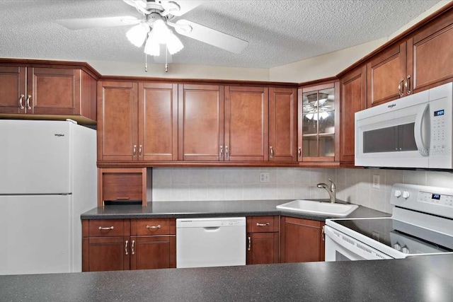 1127 Pine Ridge Cir W Unit A2, Tarpon Springs, FL 34688 - kitchen featuring white appliances, a sink, dark countertops, glass insert cabinets, and a ceiling fan