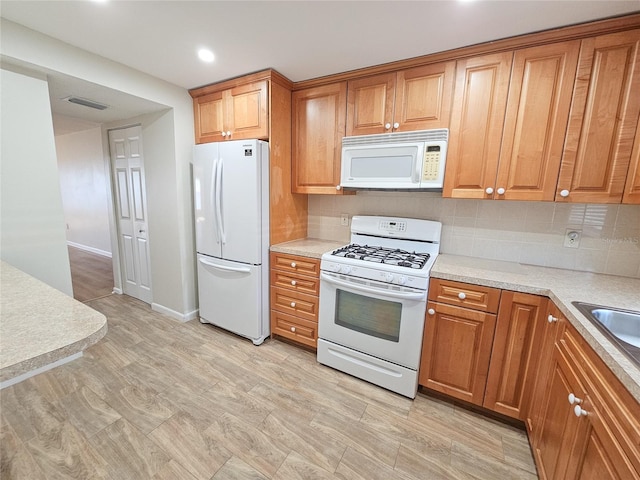 kitchen with decorative backsplash and white appliances