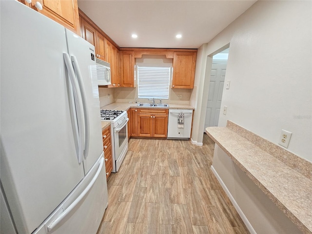 kitchen with sink, light hardwood / wood-style floors, and white appliances