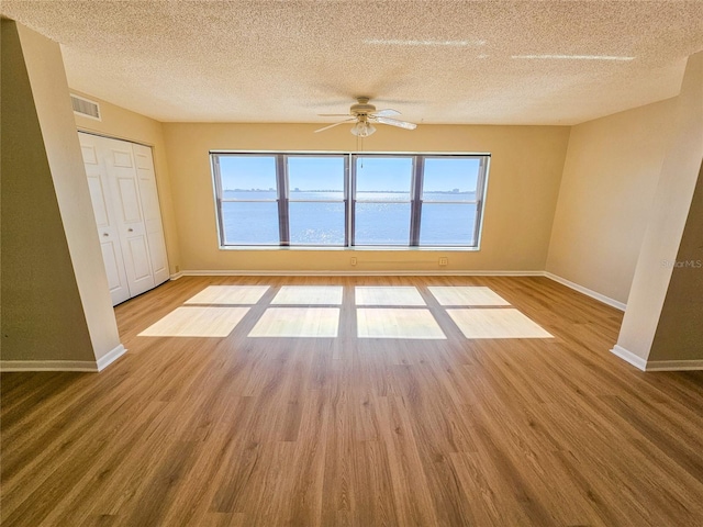 unfurnished room featuring hardwood / wood-style flooring, a healthy amount of sunlight, and a textured ceiling