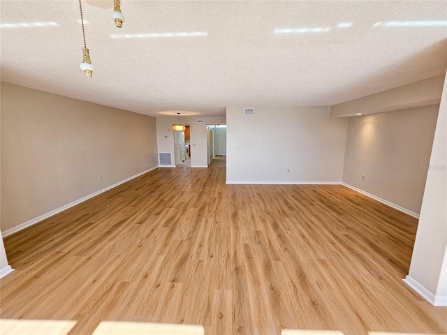 unfurnished living room featuring a textured ceiling and hardwood / wood-style flooring