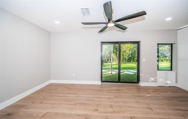 empty room with ceiling fan and light hardwood / wood-style floors