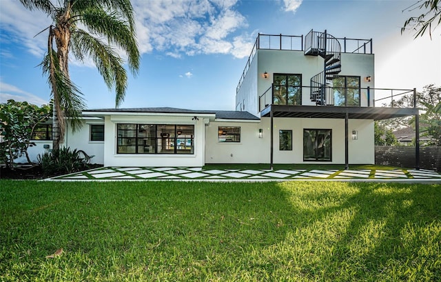 rear view of property featuring a balcony and a lawn