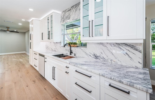 kitchen with light stone counters, white cabinets, and a healthy amount of sunlight