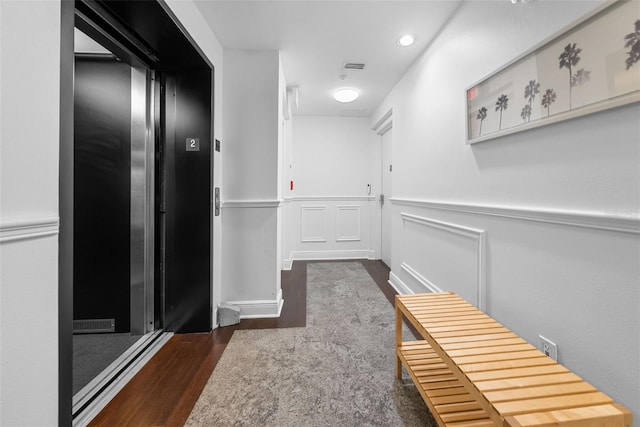 corridor featuring dark wood-type flooring and elevator