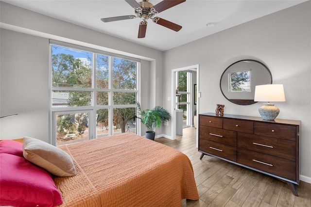 bedroom featuring multiple windows, ceiling fan, and light wood-type flooring