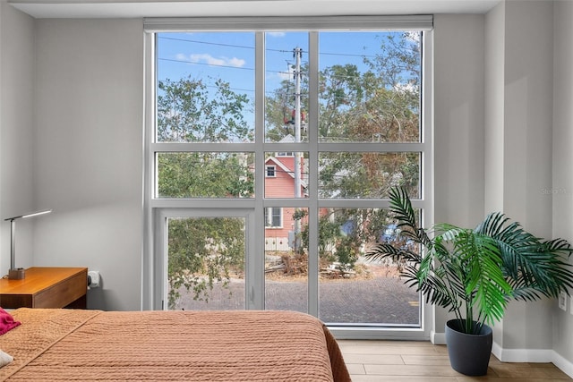 bedroom with multiple windows and light wood-type flooring