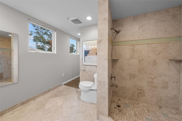 bathroom with tiled shower, tile patterned floors, and toilet