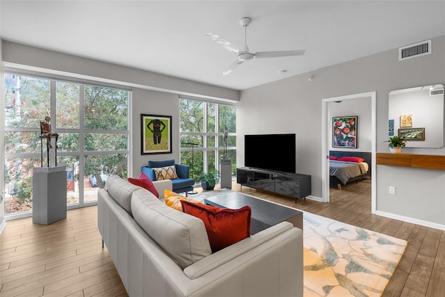 living room with a wealth of natural light, ceiling fan, and wood-type flooring