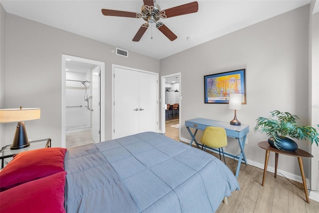 bedroom with a closet, ensuite bath, ceiling fan, and light hardwood / wood-style flooring