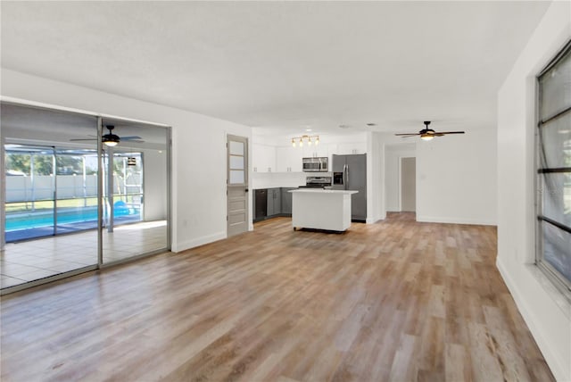 unfurnished living room featuring ceiling fan and light hardwood / wood-style floors