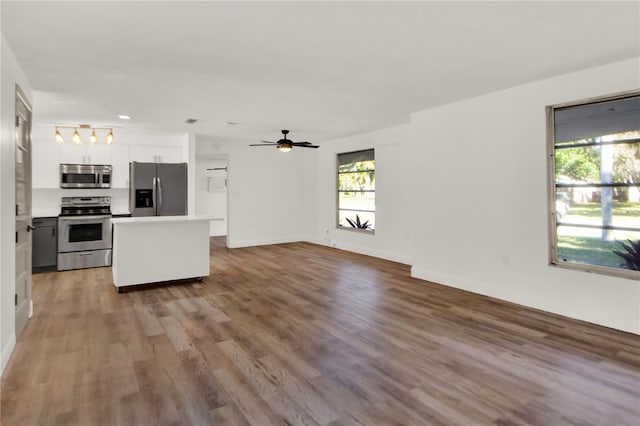 kitchen featuring white cabinetry, a wealth of natural light, hardwood / wood-style floors, and stainless steel appliances