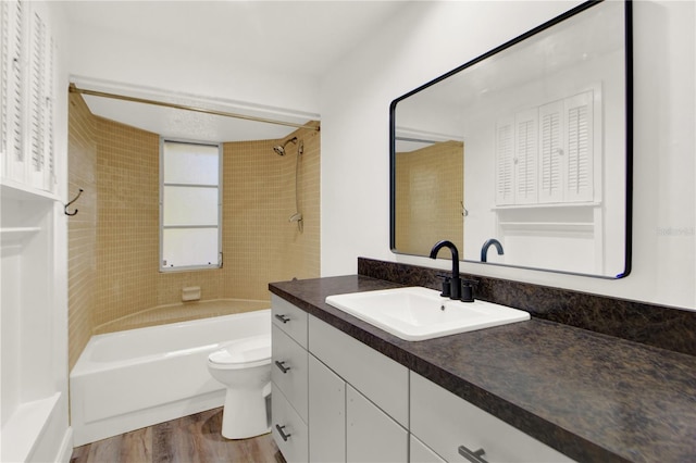 full bathroom with hardwood / wood-style floors, vanity, toilet, and tiled shower / bath combo