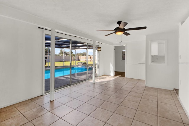 spare room featuring ceiling fan, a textured ceiling, and light tile patterned floors