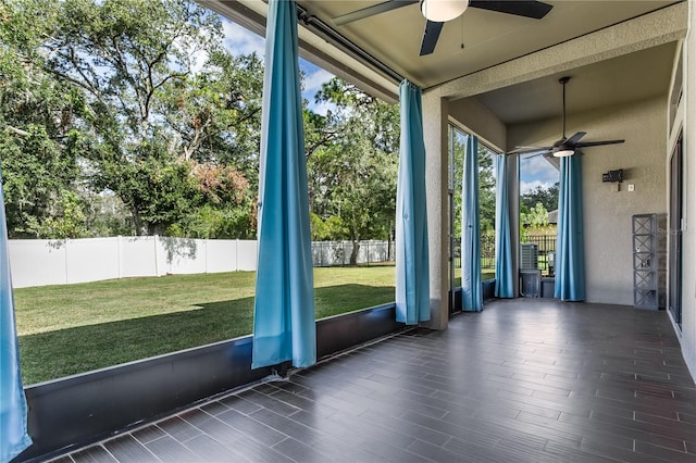 unfurnished sunroom featuring a wealth of natural light and ceiling fan