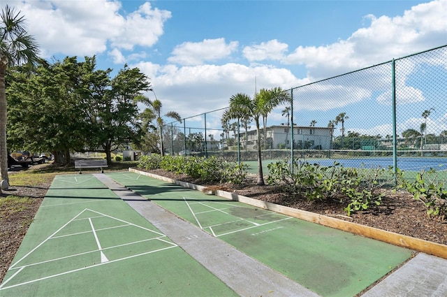 view of home's community featuring tennis court