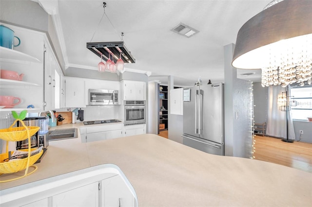 kitchen with sink, tasteful backsplash, light hardwood / wood-style floors, white cabinetry, and stainless steel appliances