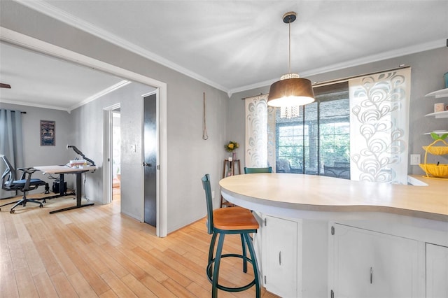 kitchen with decorative light fixtures, light hardwood / wood-style floors, and crown molding