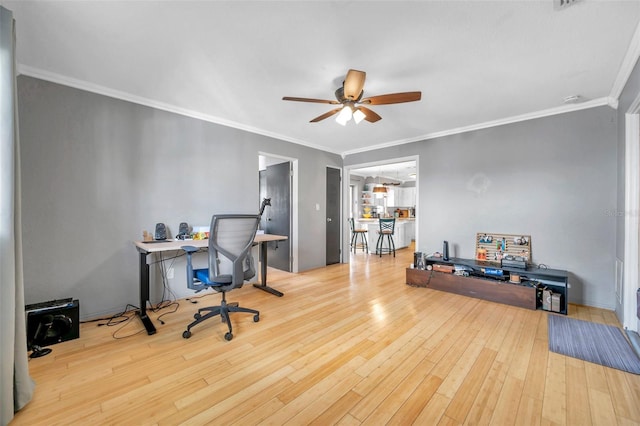 office space featuring crown molding, ceiling fan, and light hardwood / wood-style floors