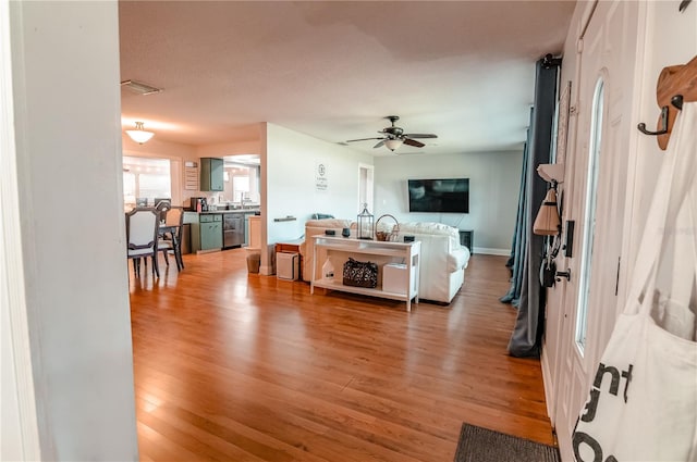 living room with ceiling fan, a textured ceiling, and hardwood / wood-style flooring