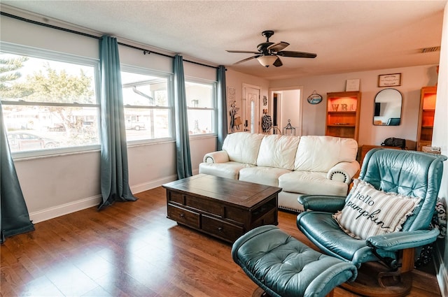 living room featuring ceiling fan, a healthy amount of sunlight, and wood-type flooring