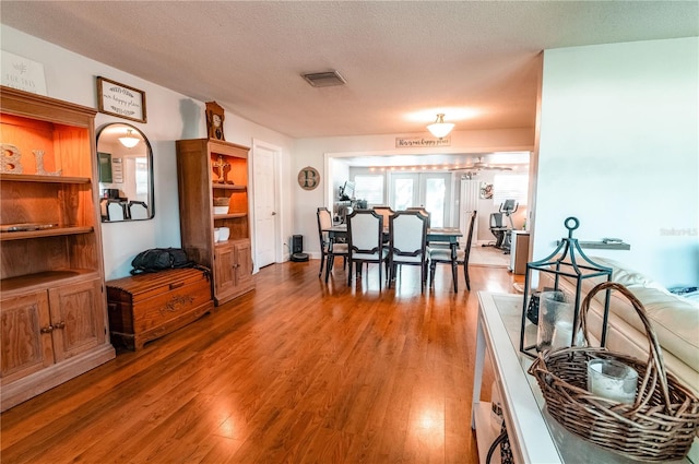 dining area with a textured ceiling and hardwood / wood-style flooring