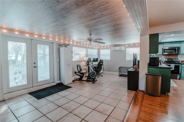 exercise room with plenty of natural light, light tile patterned floors, and french doors