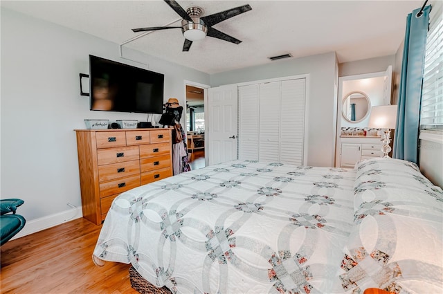 bedroom featuring ensuite bathroom, ceiling fan, a textured ceiling, wood-type flooring, and a closet