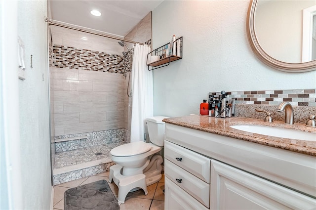 bathroom with decorative backsplash, tile patterned floors, a shower with curtain, vanity, and toilet