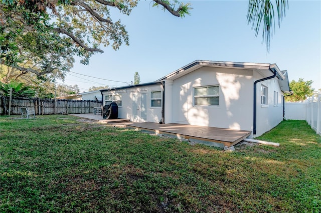 rear view of property with a yard and a deck