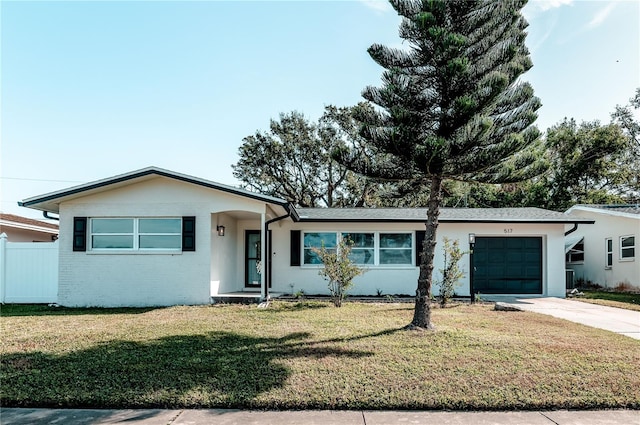 ranch-style house featuring a front lawn, driveway, fence, an attached garage, and brick siding