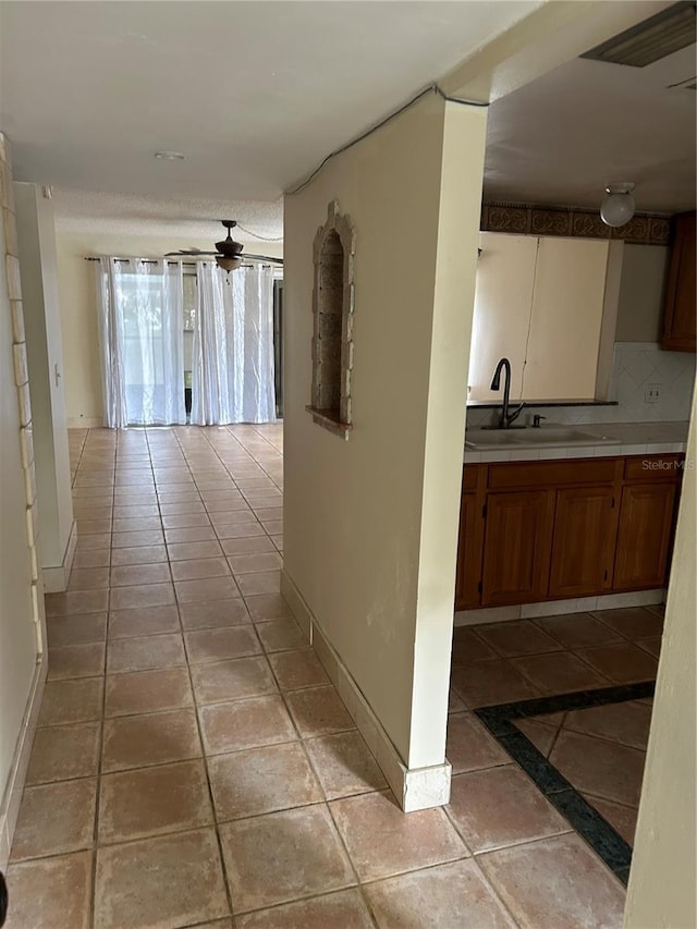 hallway with sink and light tile patterned floors