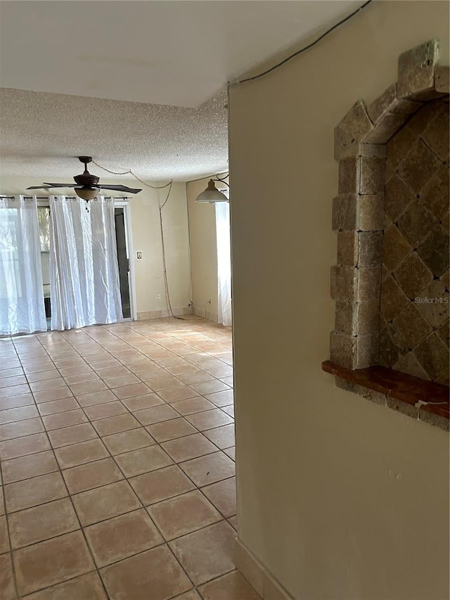 unfurnished room featuring light tile patterned flooring, a textured ceiling, and a healthy amount of sunlight