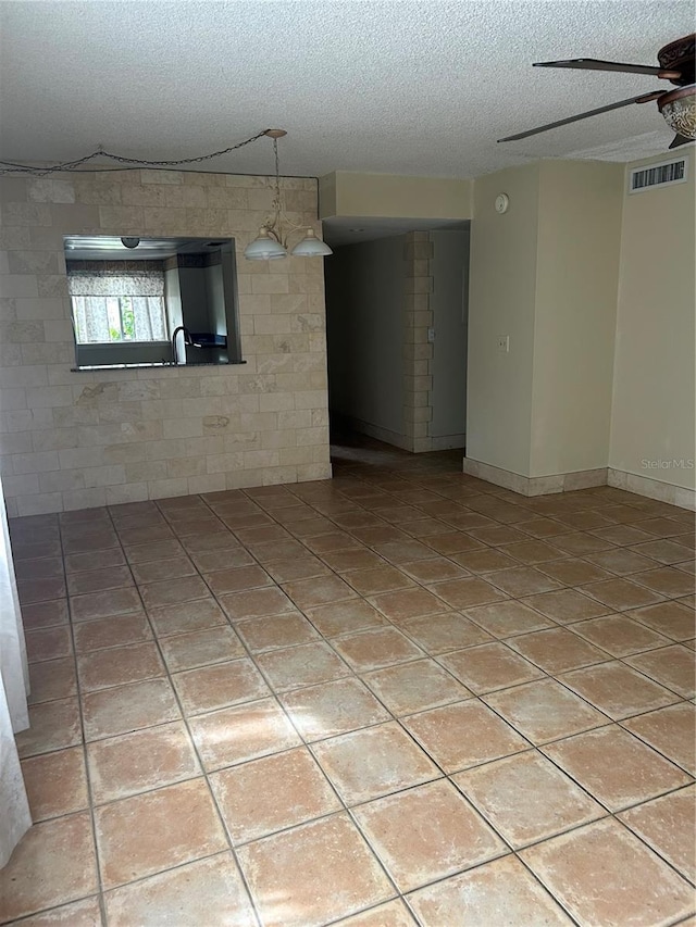 spare room featuring ceiling fan and a textured ceiling