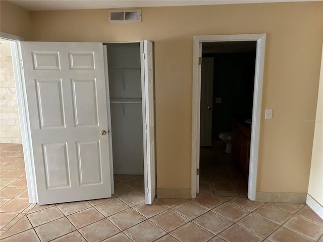 unfurnished bedroom featuring light tile patterned floors and a closet