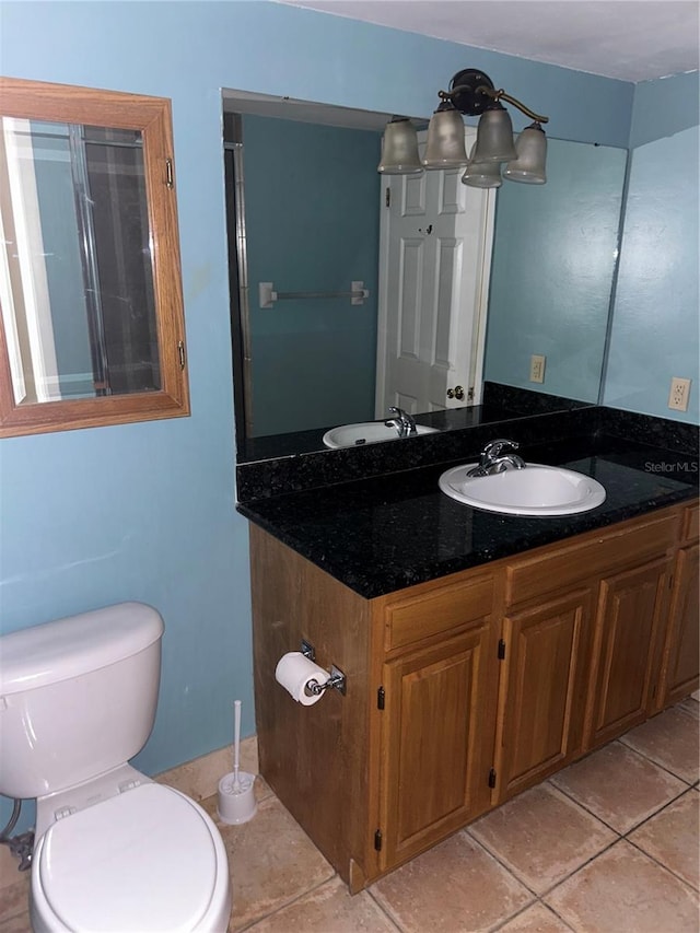 bathroom featuring toilet, vanity, and tile patterned floors