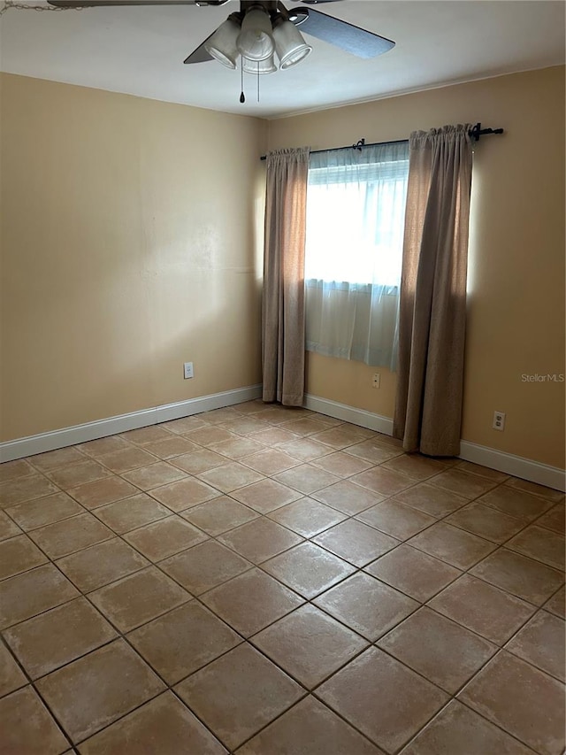 spare room with ceiling fan and light tile patterned floors