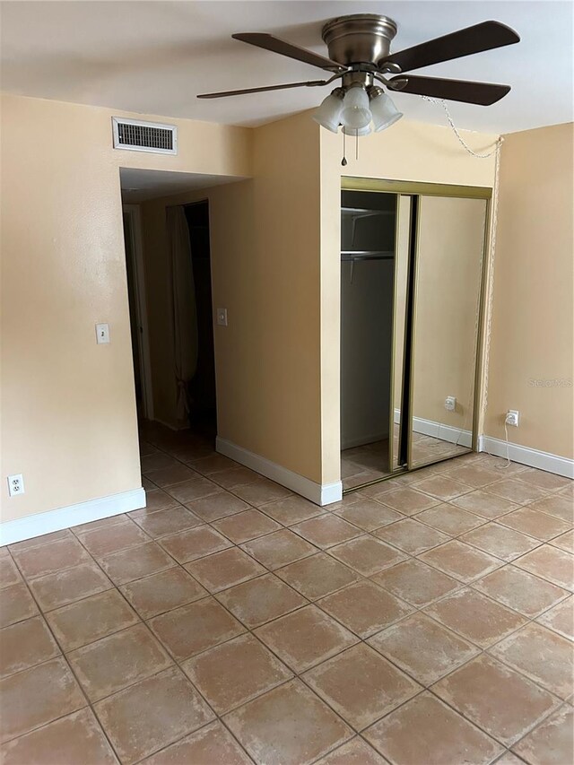 unfurnished bedroom featuring ceiling fan and a closet