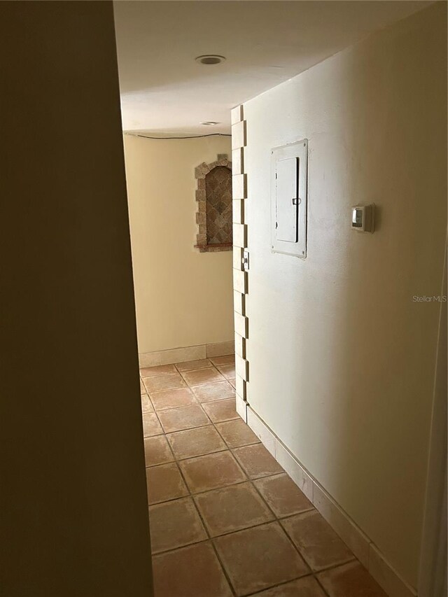 hall featuring electric panel and tile patterned flooring