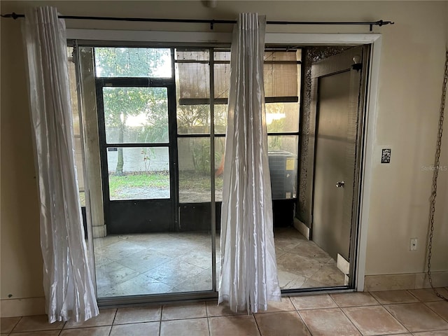 doorway to outside with light tile patterned floors