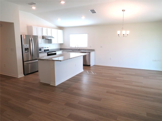 kitchen featuring a center island, lofted ceiling, dark hardwood / wood-style floors, appliances with stainless steel finishes, and decorative light fixtures