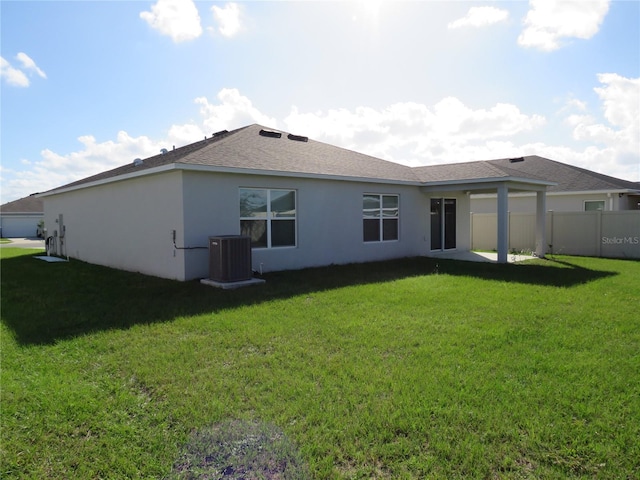 back of house with a lawn and central AC