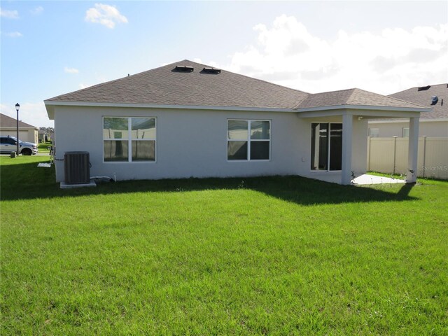 148 Summerlin Loop, Haines City, FL 33844 - rear view of house with cooling unit, stucco siding, and roof with shingles
