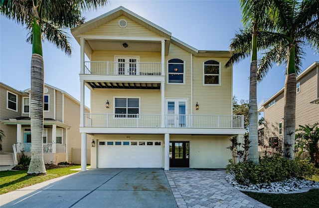 view of front of property with french doors, a balcony, and a garage