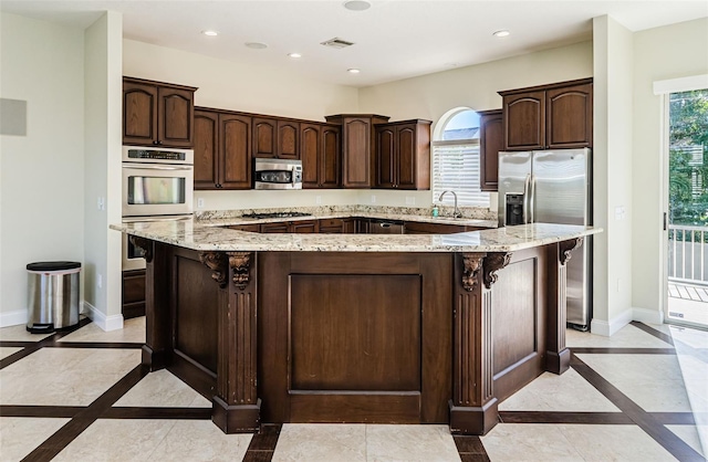 kitchen with dark brown cabinetry, stainless steel appliances, and a center island