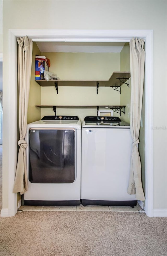 laundry area with washer and clothes dryer and light carpet