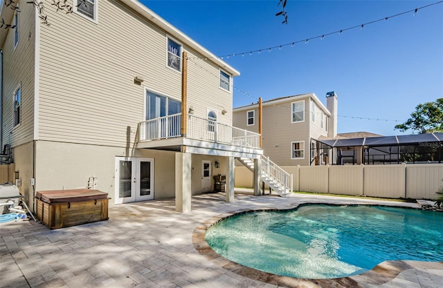 view of pool with french doors, a hot tub, and a patio