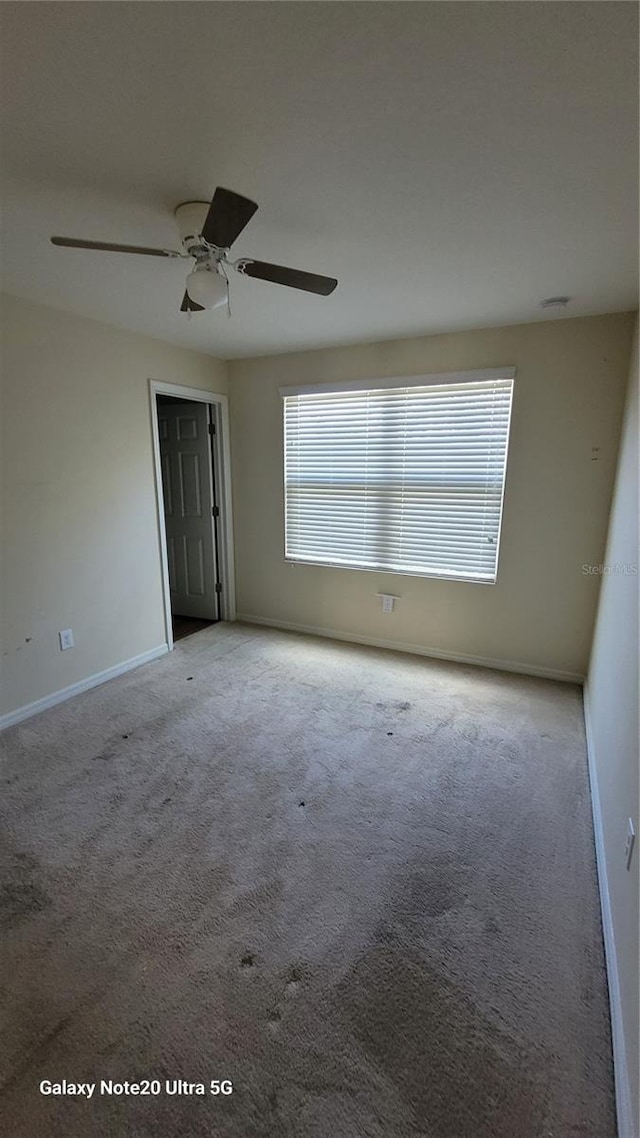 carpeted empty room with ceiling fan