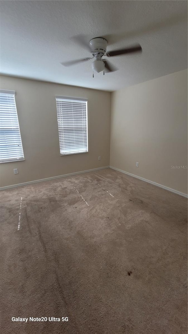 unfurnished room featuring ceiling fan and carpet floors